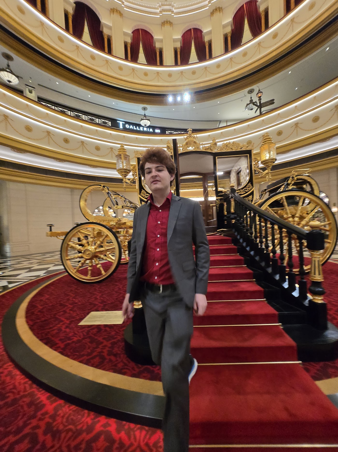 Cameron wearing a blazer on an ornate staircase